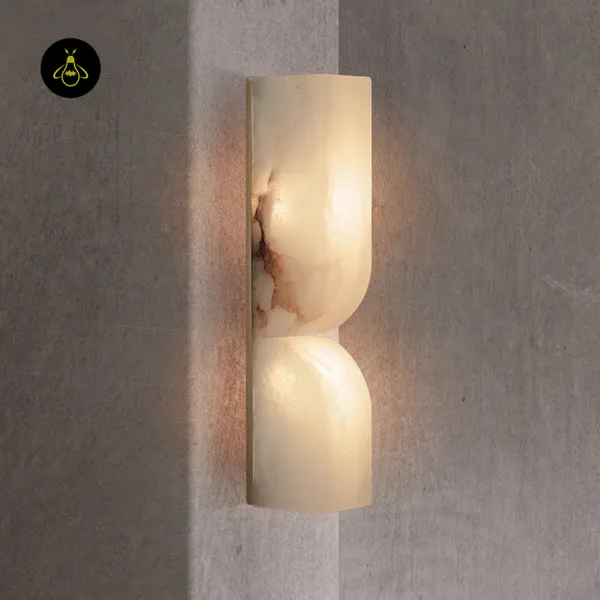Alabaster wall light on a textured grey hallway wall, warm wash