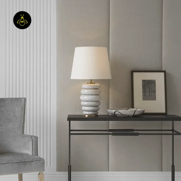 Stacked ceramic table lamp on a console with brass base and stacked white ceramic rings