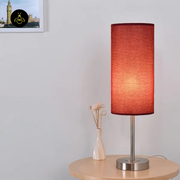 Rust-red fabric table lamp giving warm ambient light in a cosy room
