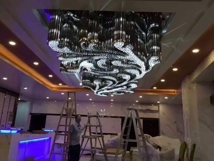 Golden-trimmed crystal swirl details on the banquet chandelier at Topaz Radiance Surat