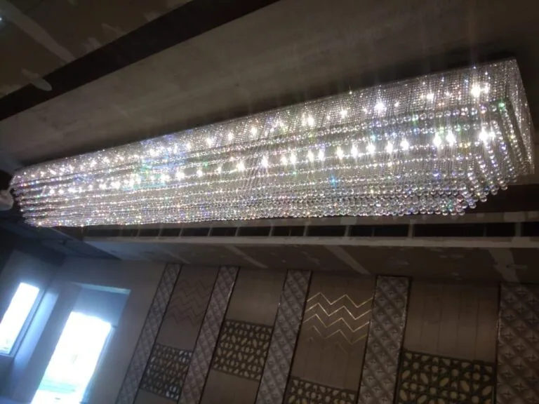 Banquet chandelier Pune: the 24-foot crystal slab showpiece glowing across a real banquet hall ceiling, built by JagMag Lights