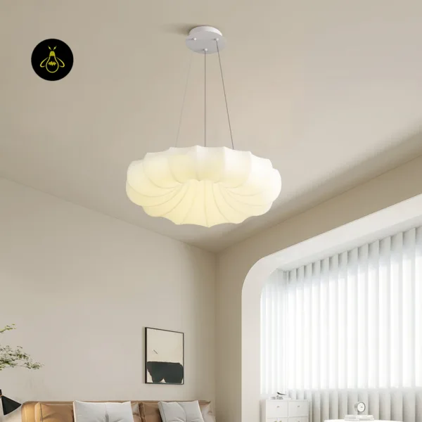 Cloud hanging light glowing above a living room with a beige sofa and a white arched window