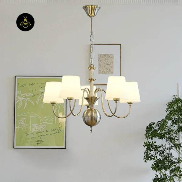 White fabric chandelier illuminated above a dining table