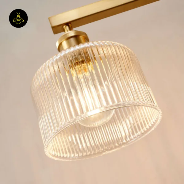 Ribbed glass chandelier shade close-up: clear borosilicate glass with the bulb glowing