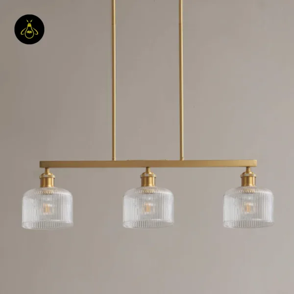 Ribbed glass chandelier unlit against a grey wall, three clear shades on the bar