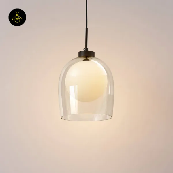 Calypso pendant switched on against a warm wall, the opal globe glowing inside the clear bell of this glass hanging lamp