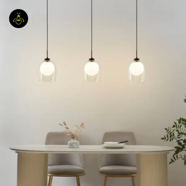 Three glass hanging lamps glowing in a row over an oval dining table with fluted base