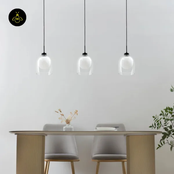 Three Calypso glass hanging lamps switched off over an oval dining table in a light grey room