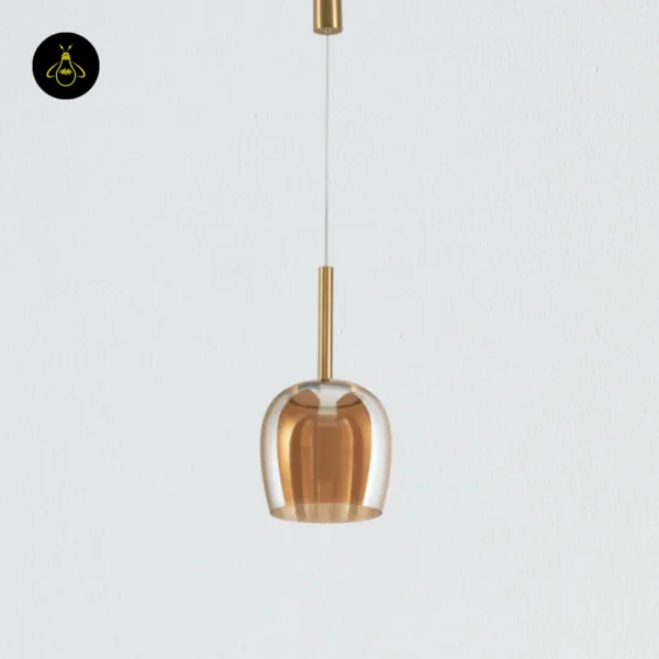 Bell pendant light unlit, hanging on its cable from a brass-finish canopy, amber borosilicate glass bell