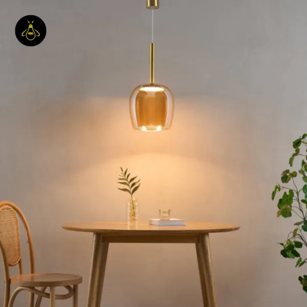 Bell pendant light lit over a round wooden dining table with a cane chair