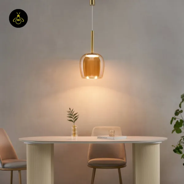Bell pendant light lit above a white dining table with ribbed pedestal legs
