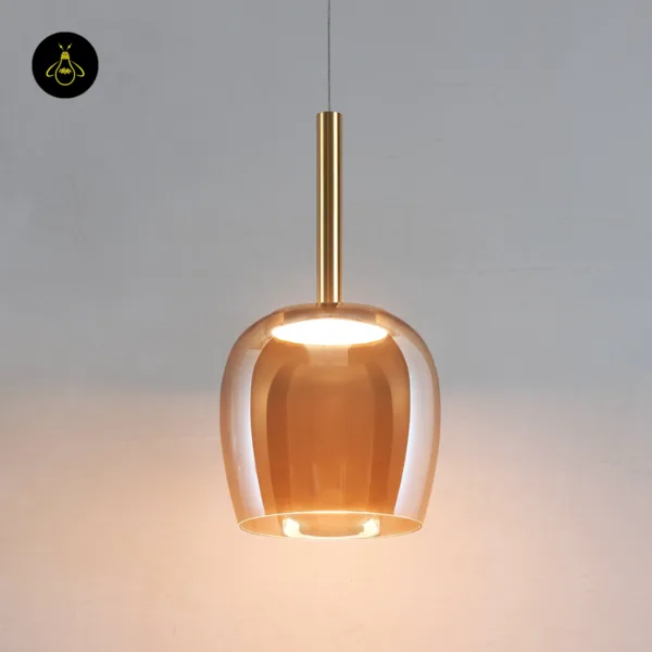 Bell pendant light lit, two layers of amber borosilicate glass under a brass-finish stem, front view