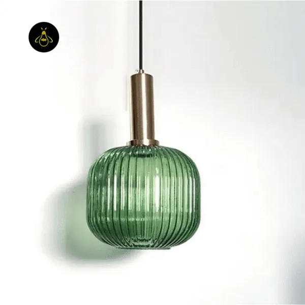 Green fluted glass pendant light hanging against a white wall, ribbed borosilicate glass barrel with brass-finish holder