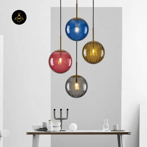 Globe hanging light cluster in blue, pink, gold-lustre and smoked glass over a white dining table