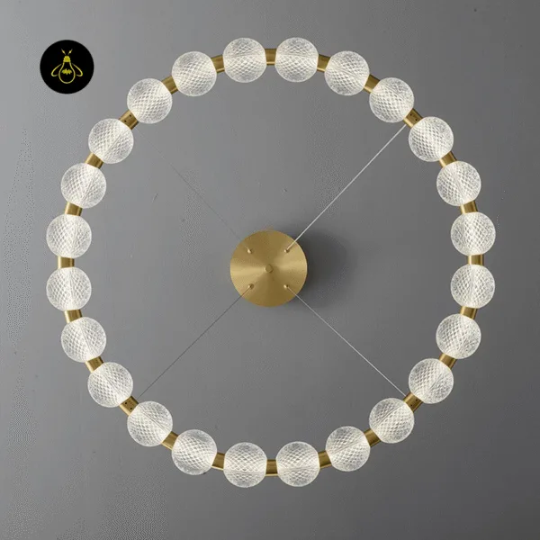 Beaded ring chandelier glowing above a bed with warm LED light in a modern bedroom