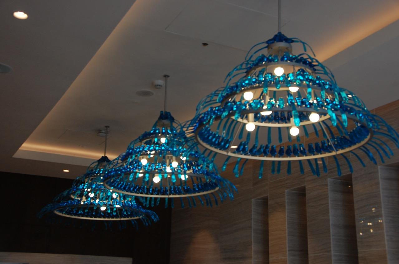Bespoke hotel chandelier flock — three blue bird ring chandeliers in a row at Hyatt Regency Addis Ababa