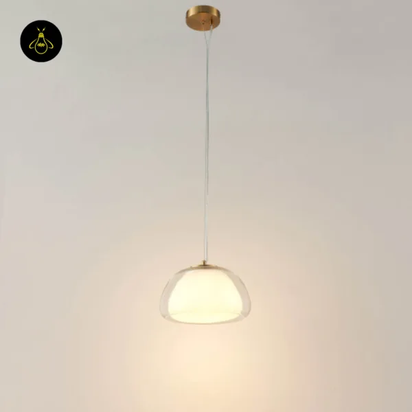 Lomelia double glass pendant light hanging from a round gold-finish ceiling canopy on a transparent cord, lit with a warm glow