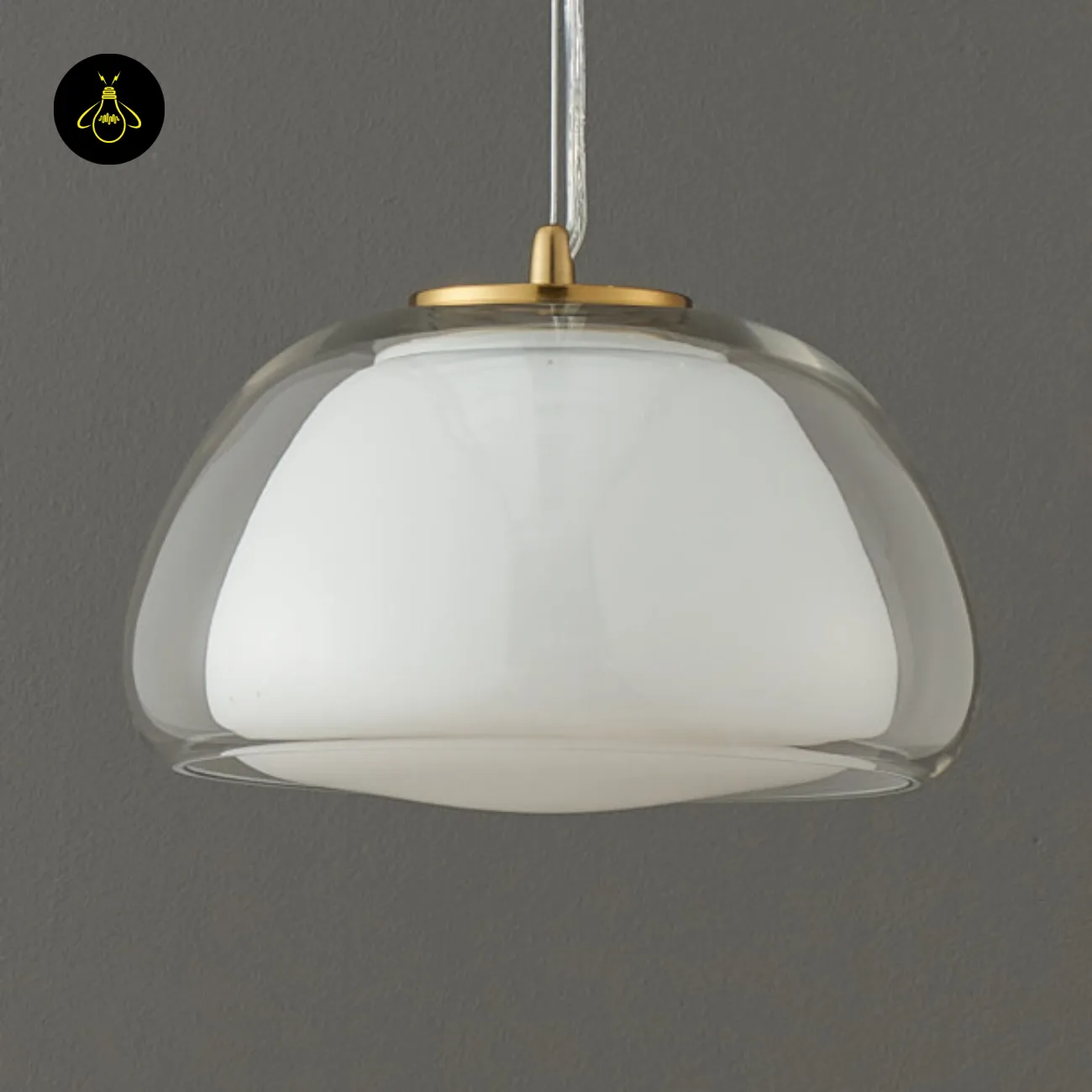 Double Glass Pendant Light – Lomelia 25 cm Dome, Gold Finish 7 Lomelia double glass pendant light switched off against a grey wall, white opal inner shade inside the clear outer dome, gold-finish cap