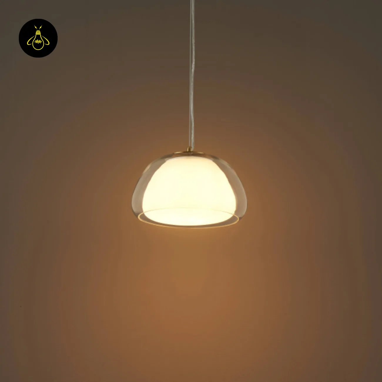 Double Glass Pendant Light – Lomelia 25 cm Dome, Gold Finish 11 Lomelia double glass pendant light lit in a dark room, 25 cm dome on a transparent cord casting a warm pool of light