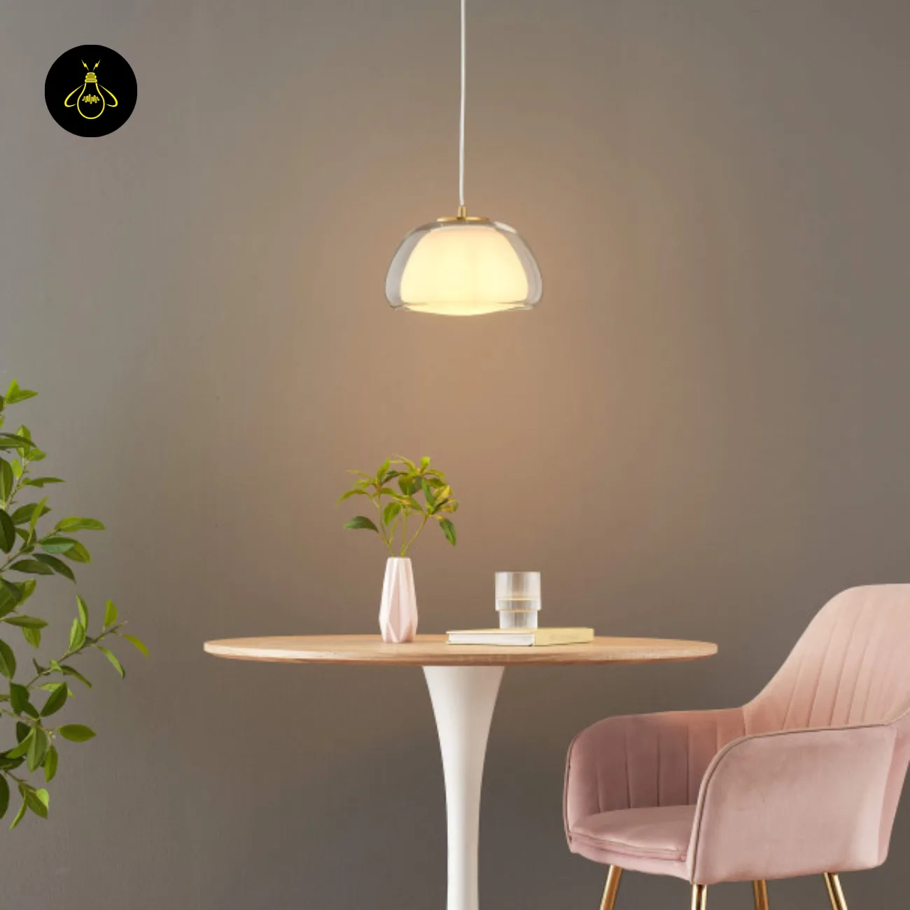 Double Glass Pendant Light – Lomelia 25 cm Dome, Gold Finish 14 Lomelia double glass pendant light glowing over a round wood-top table with a white pedestal base and pink armchair