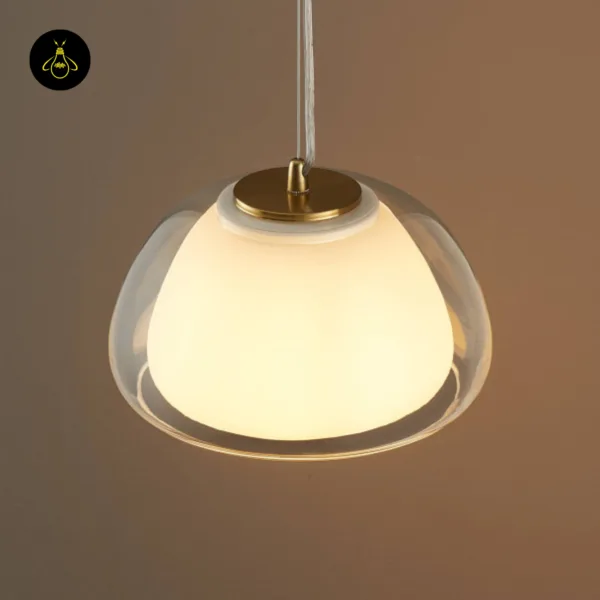 Top-side view of the Lomelia double glass pendant light, gold-finish 304 stainless steel cap seated on the opal inner shade inside the clear outer dome