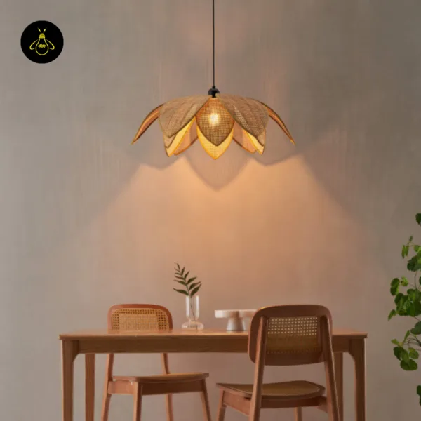 Lit lotus cane pendant light centred over a dining table with two cane chairs