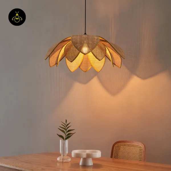 Close view of a lit cane pendant light over a wooden table with a small vase