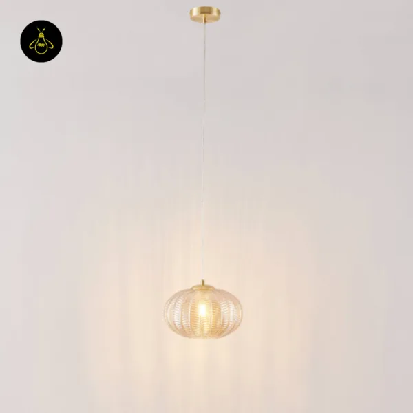 Amber textured glass pendant light hanging on a long clear cord from a brass-finish canopy