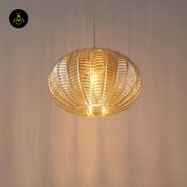 Amber textured glass pendant light glowing against a warm wall, front view