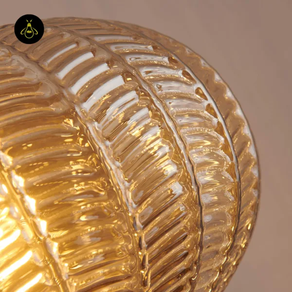 Close-up of the leaf-pattern relief on an amber textured glass pendant light