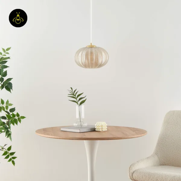 Textured glass pendant light, unlit, above a round wooden table and a cream chair