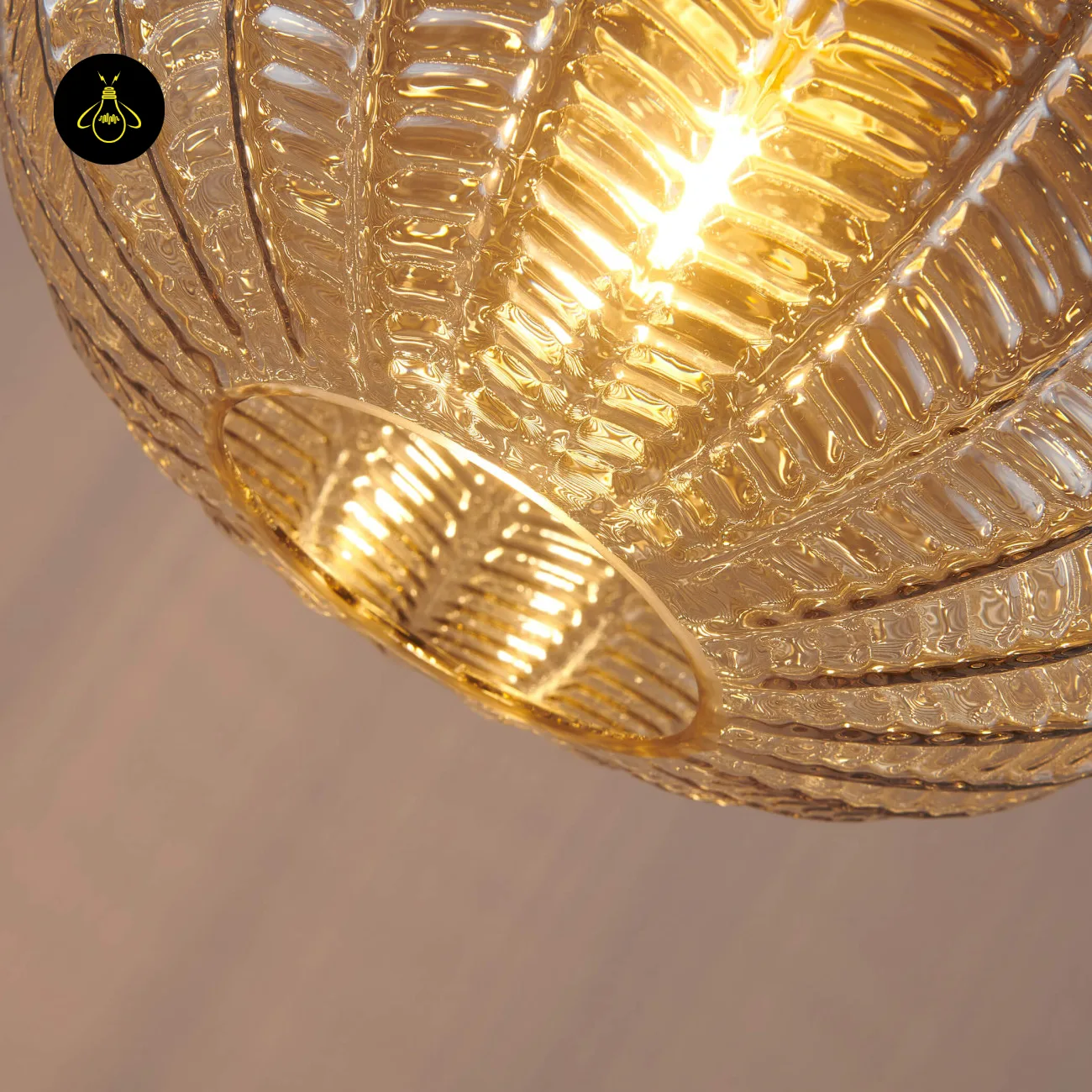 Textured Amber Glass Pendant Light – 26 cm Globe, Brass Finish, E27 10 Underside of a lit textured glass pendant light, seen through the open base