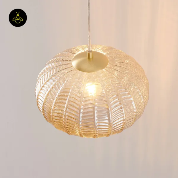 Top view of a textured glass pendant light with its brass-finish cap and leaf-pattern ribs