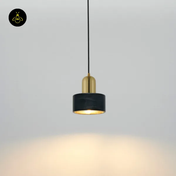 Marble hanging light lit against a grey wall, throwing a warm pool of light downward