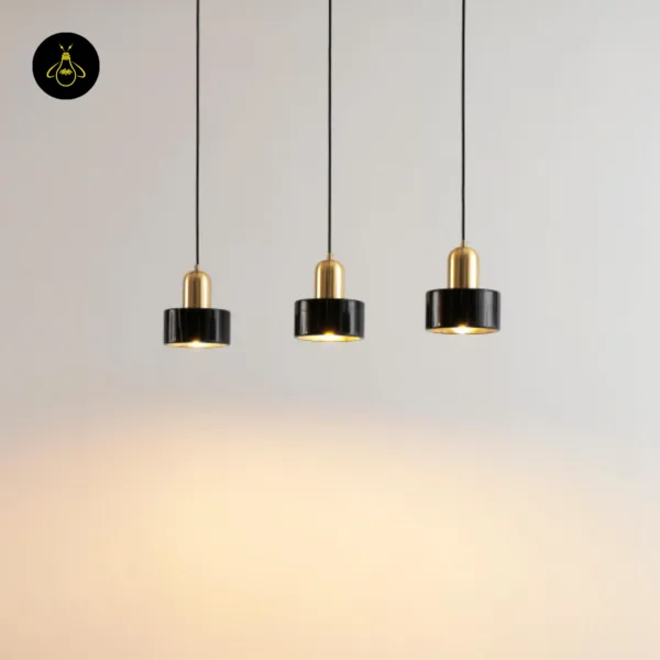 Three marble hanging lights at staggered heights casting warm light on a wall