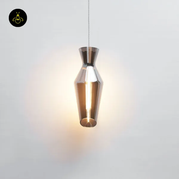 Lit faceted smoked glass pendant light on a clear twisted cord, soft halo on a pale wall