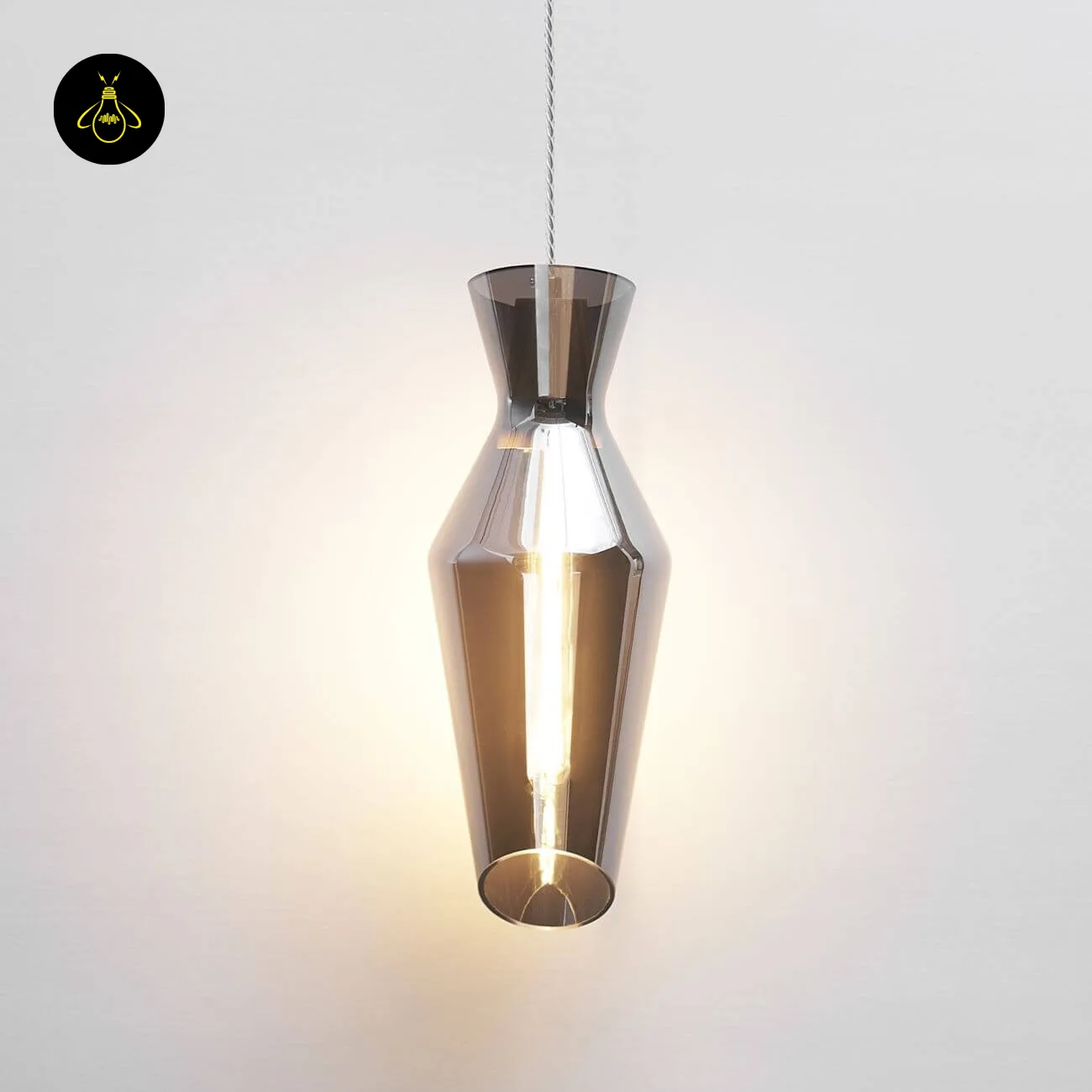 Faceted Smoked Glass Pendant Light – Loft Drop Form, 40 cm 2 Faceted smoked glass pendant light switched on against a white wall, warm glow through the smoked borosilicate glass
