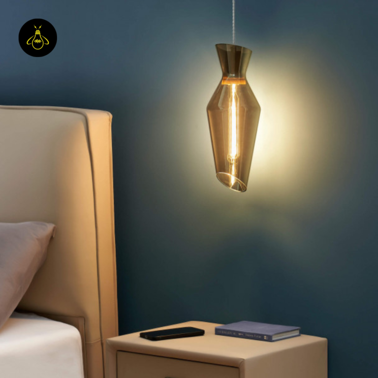 Faceted smoked glass pendant light hanging beside a bed as a bedside drop light