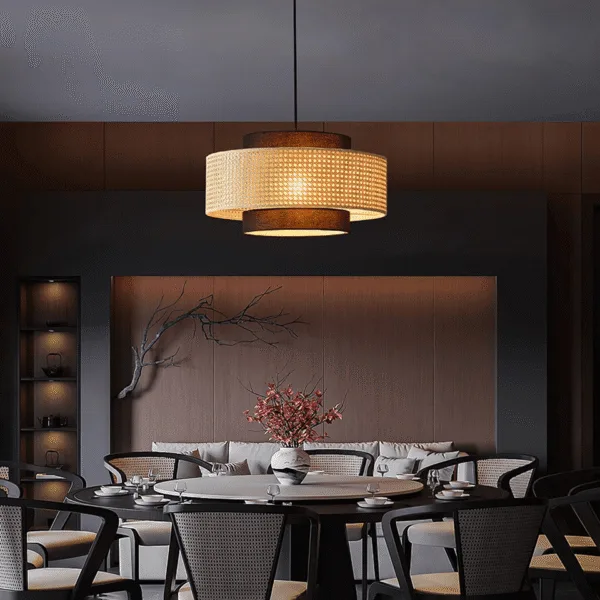 Japanese rattan pendant light, Drum Shade finish, lit above a round dining table in a dark wood-panelled room