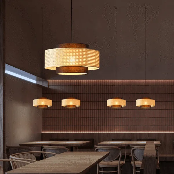 Japanese rattan pendant lights, Drum Shade finish, lit in a row above wooden tables in a cafe