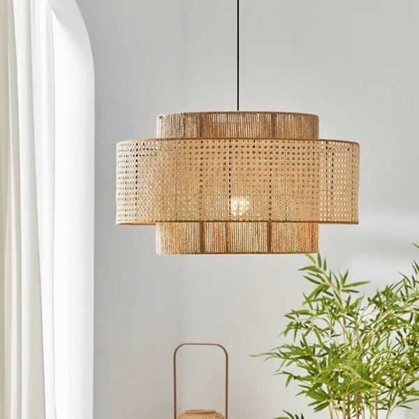 Japanese rattan pendant light, Japanese Concentric finish, glowing beside a white curtain and a bamboo plant