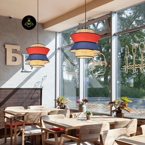 Rattan and fabric pendant light angled view showing red and blue linen tiers and cane drums