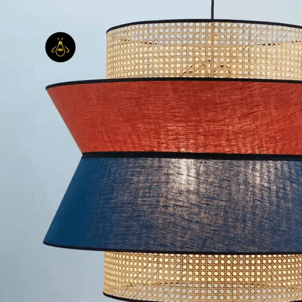 Rattan and fabric pendant light lit with warm glow through woven cane and linen tiers