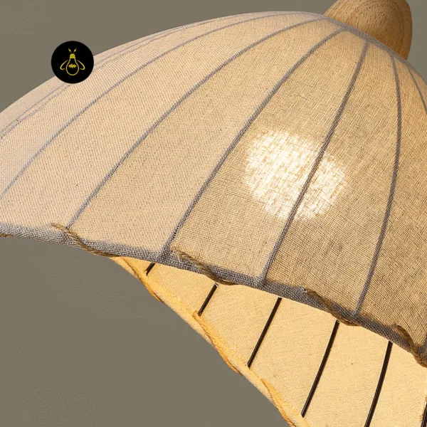 Close-up of the linen cloth pendant light: natural linen weave, stitched rib lines, twisted cord on the hem and the wood cap
