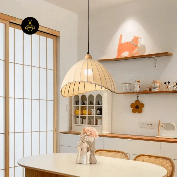 Linen cloth pendant light over a white dining table in a bright kitchen-dining nook with cane chairs