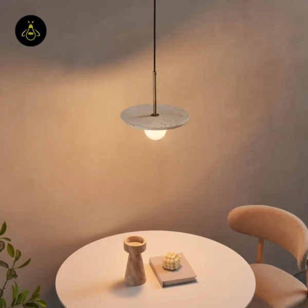 Stone pendant light lit over a small round dining table with a chair