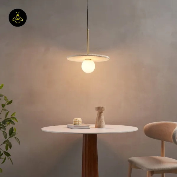 Stone pendant light lit over a round dining table and an upholstered chair