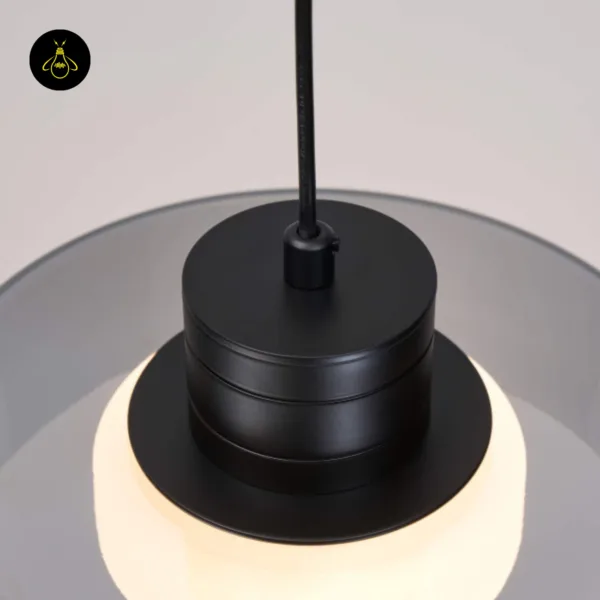 Close-up of the matte black 304 stainless steel cap and wire grip on the smoked glass drum pendant light