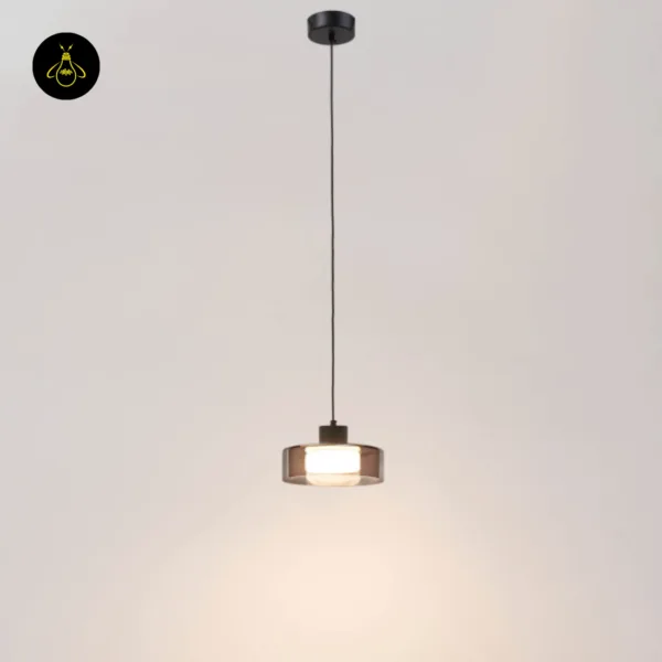 Smoked glass drum pendant light hanging from its round black ceiling canopy on a long wire