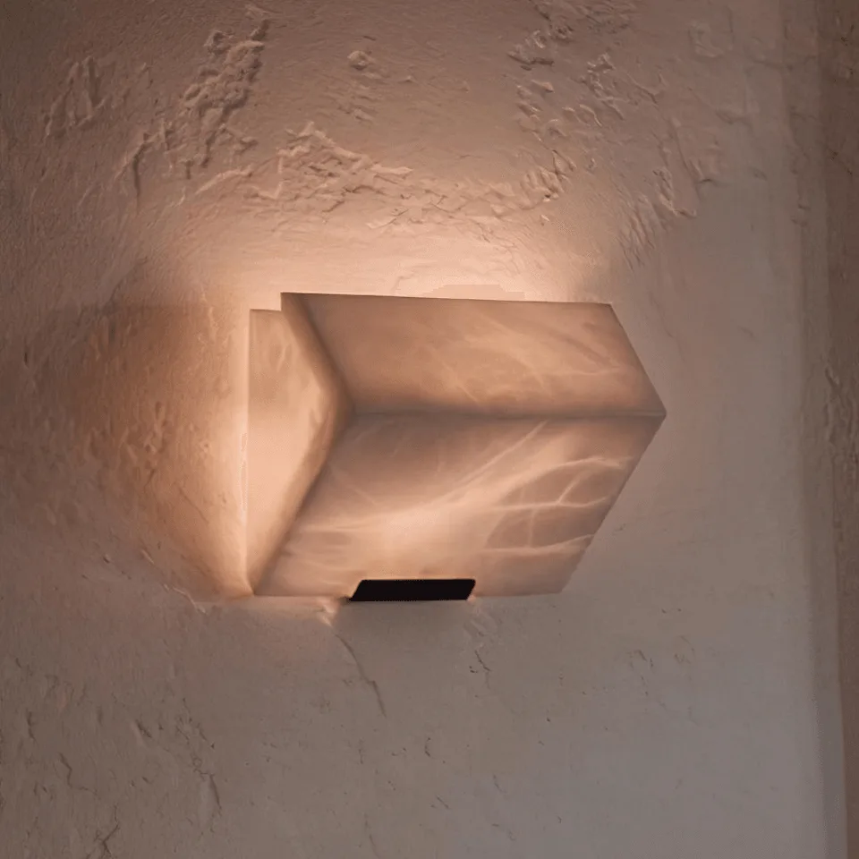 Alabaster Wall Lamp – Sculptural 15 cm Natural-Stone LED Sconce 2 Alabaster stone wall light glowing warm on a textured plaster wall, light washing up the wall